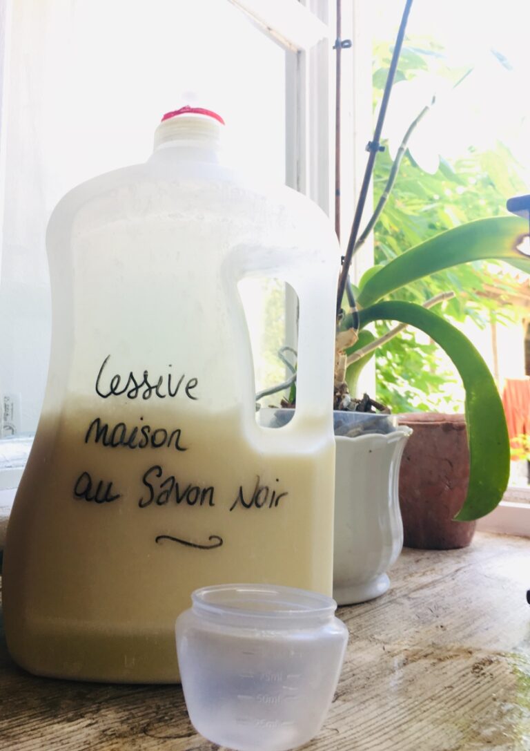 Pot de lessive maison au savon noir avec des ingrédients en arrière-plan