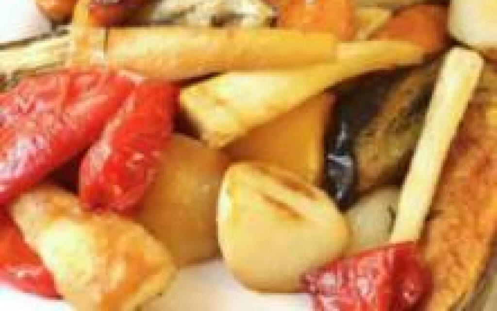 Rôti de porc juteux entouré d'une variété de légumes savoureux, parfait pour un repas gourmand